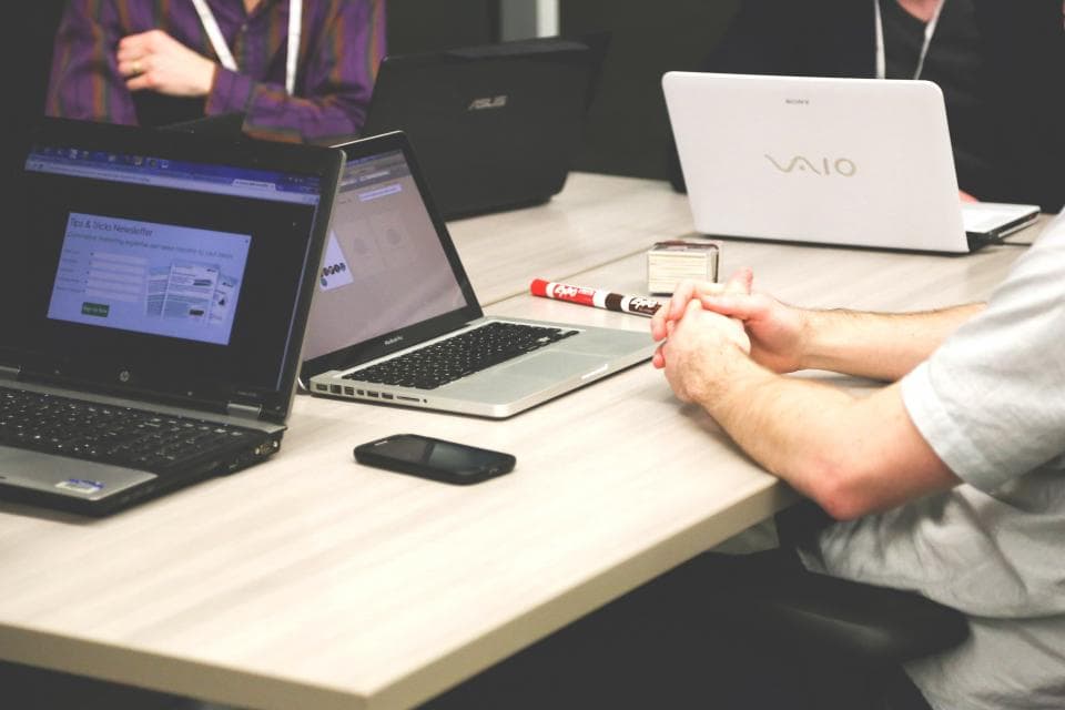 Colleagues working on laptops around a shared office table